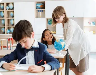 Instructor helping two children learn in a classroom setting for holiday programs.